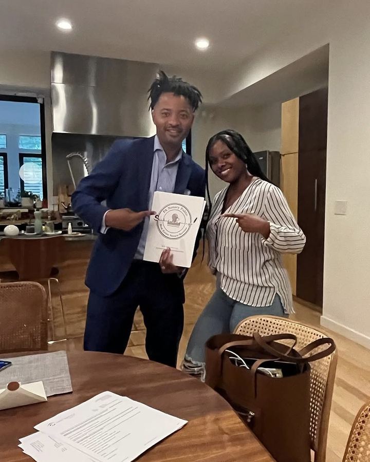 Khalia Luff and a client reviewing real estate closing documents at the kitchen table in Philadelphia