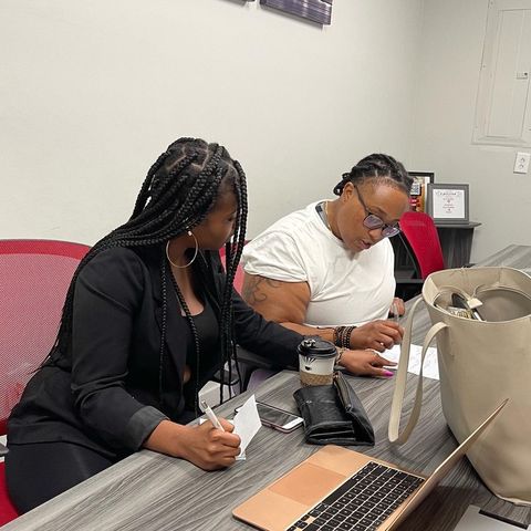 Khalia Luff reviewing settlement documents with a client at the signing table